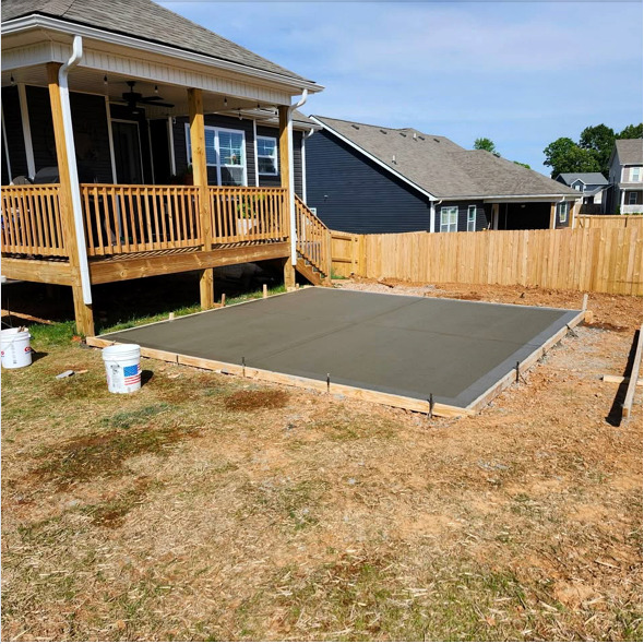 Finished concrete patio beside a backyard deck
